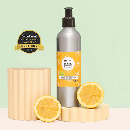 Bottle of Hairy Jayne conditioner with lemon slices and a green background with 'Best Buy' award