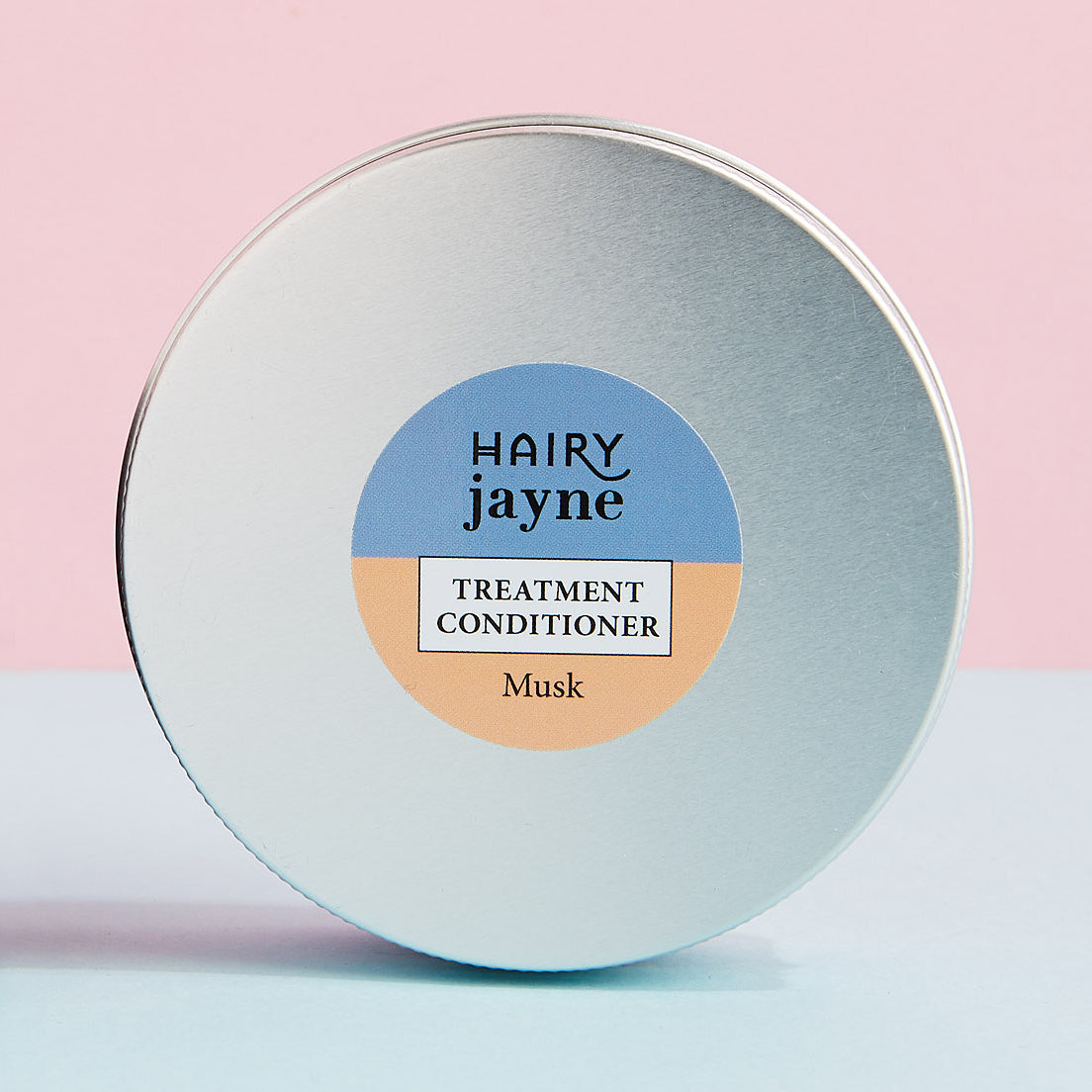 Hairy Jayne treatment conditioner container with a pink and blue gradient background