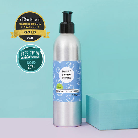Bottle of Hairy Jayne treatment conditioner with awards on a teal background