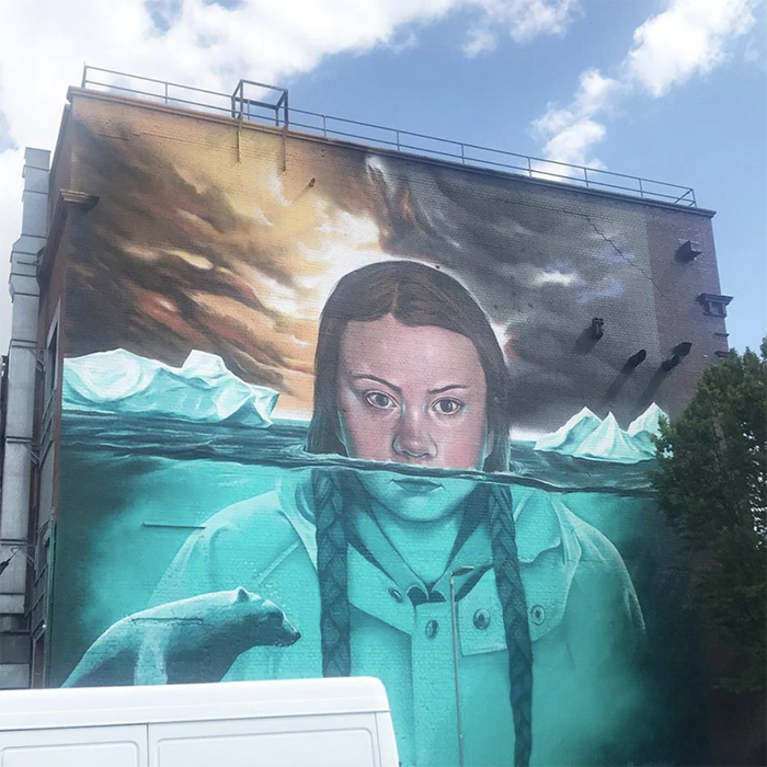mural of street art on a wall in south bristol, depicting a scowling greta thunberg emerging from the sea
