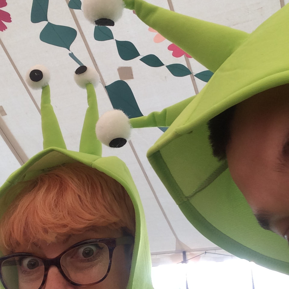 jayne and friend in snail costumes in a decorated festival tent