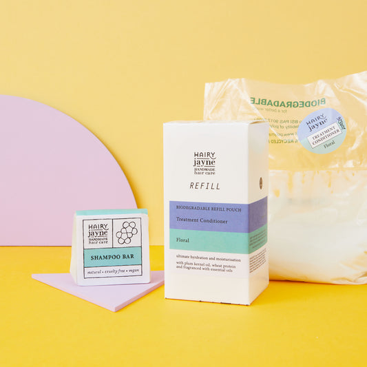 Hairy Jayne shampoo bar, refill pouch, and packaging on a yellow background