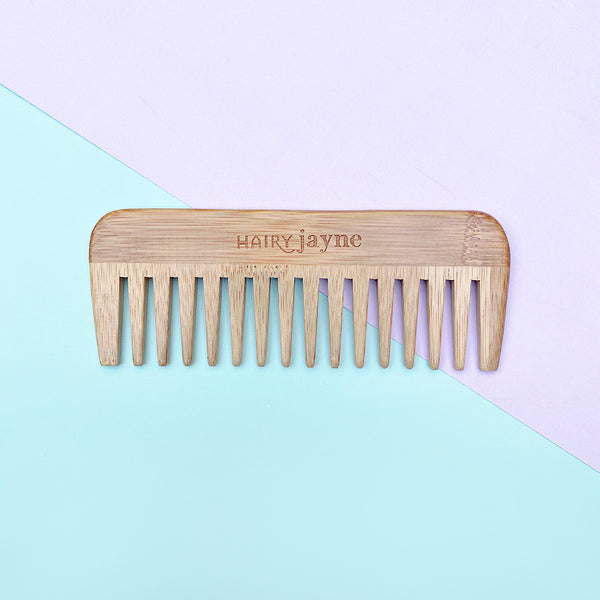 bamboo detangling comb with wide teeth and hairy jayne logo engraved into it